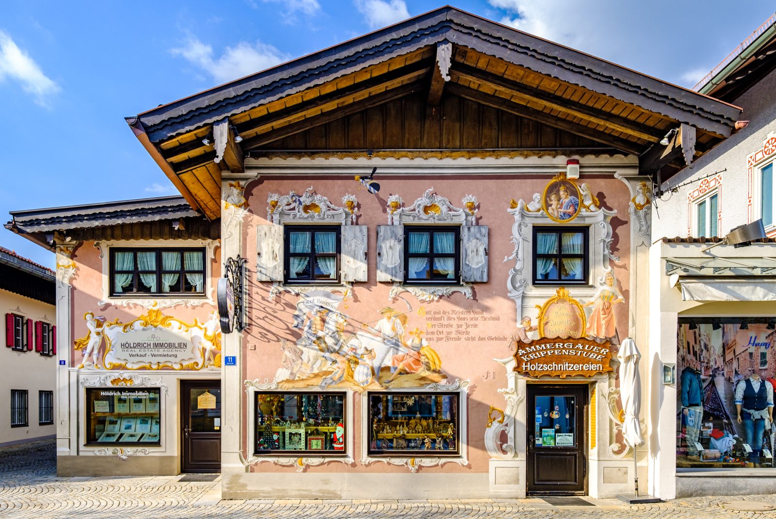     查詢成功

一張拍攝德國上巴伐利亞地區上阿瑪高某座傳統建築的正面特寫照片，該建築擁有豐富的濕壁畫（Lüftlmalerei）裝飾