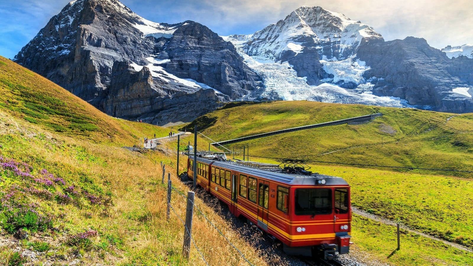 紅色列車行駛於瑞士阿爾卑斯山區與雪山之間