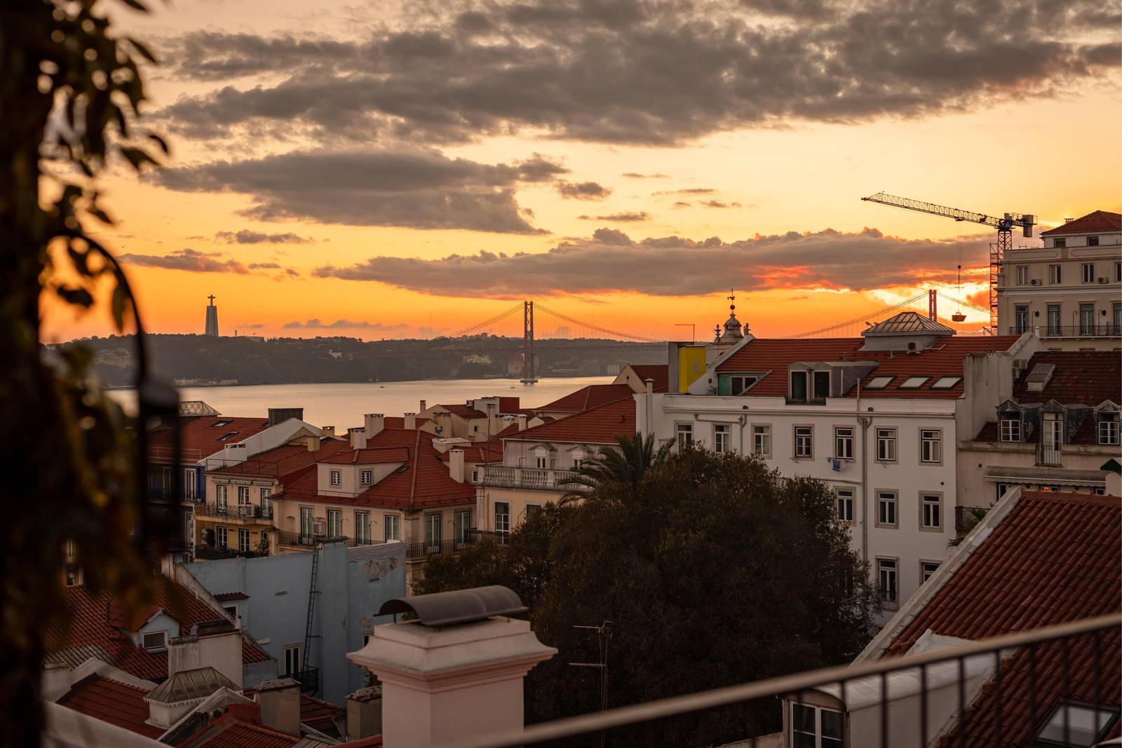 從 Bairro Alto Hotel 頂樓望向里斯本紅屋頂與太加斯河的夕陽