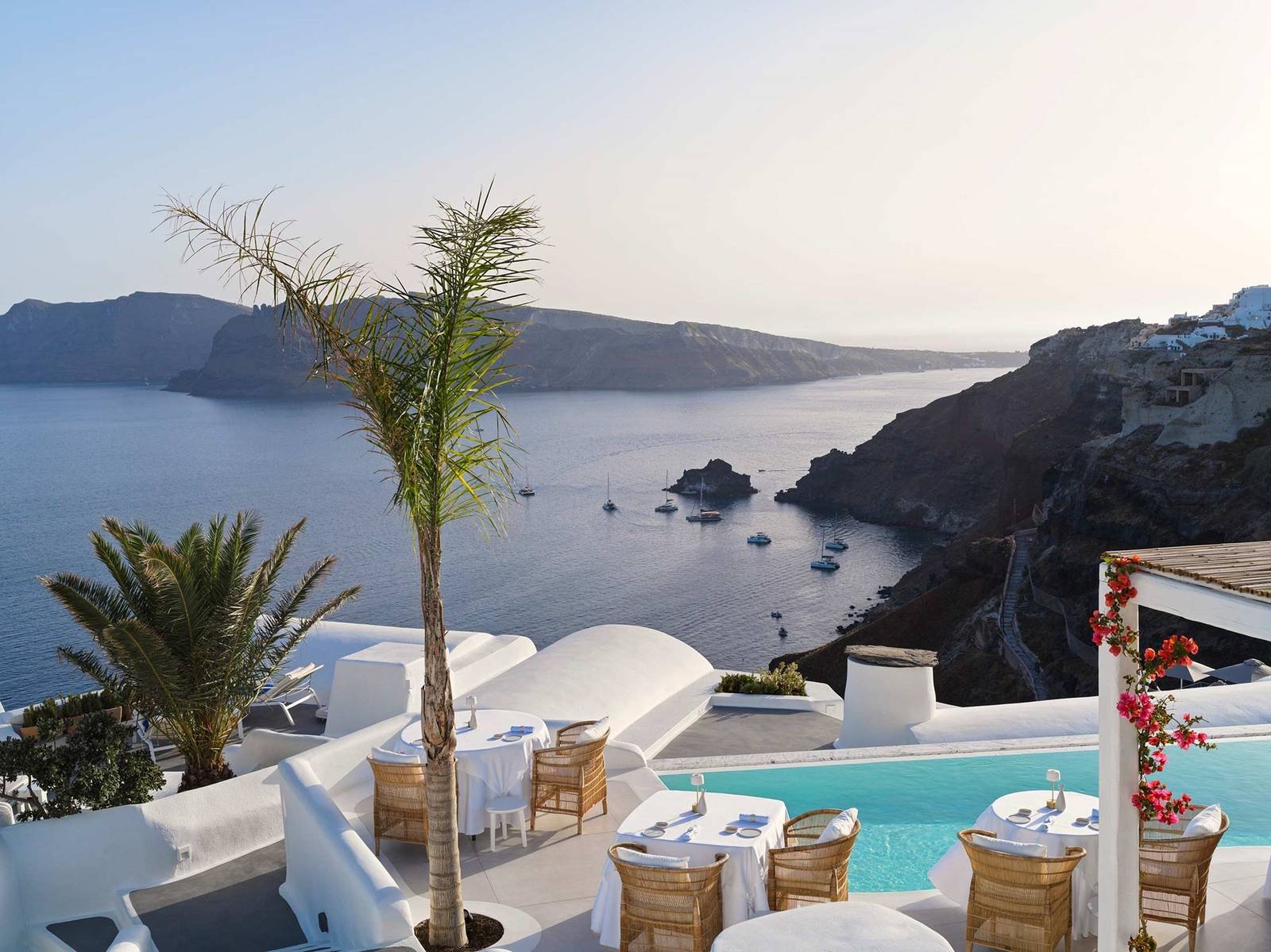 Katikies Santorini 棕櫚樹旁俯瞰海灣的露台座位