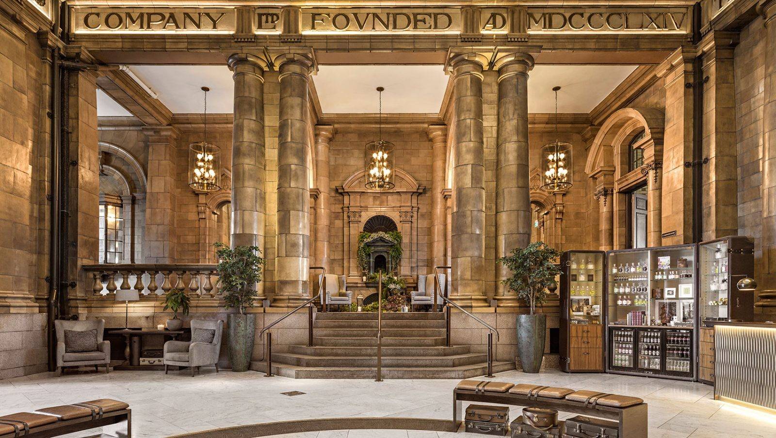 Kimpton Clocktower Hotel 保留 1890 年代陶磚立柱與銘文的挑高廳堂