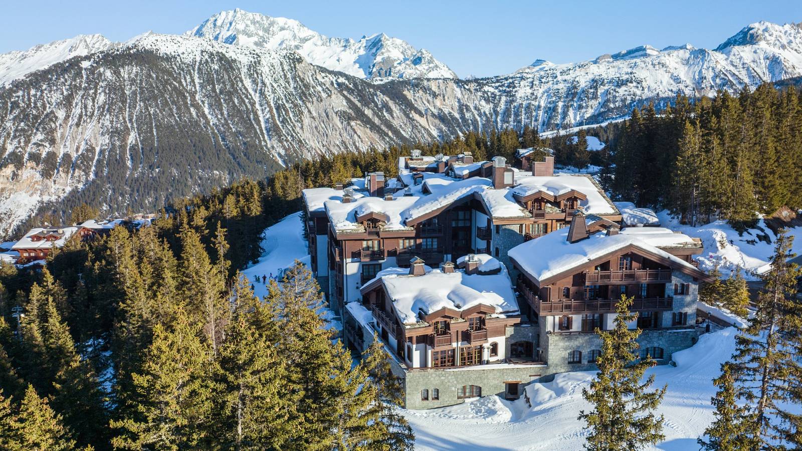 L'Apogée Courchevel 雪松林間的木造建築與背後雪山