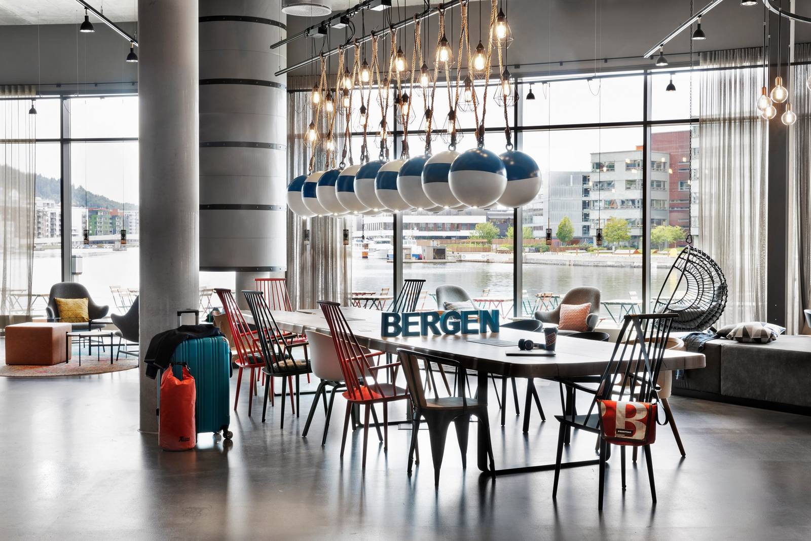 Moxy Bergen 大廳長桌與窗邊座位