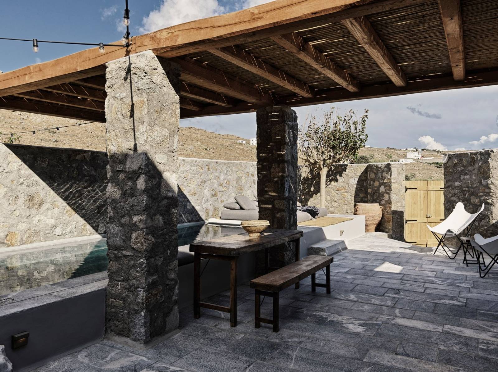 Nomad Mykonos 套房石柱涼棚下的戶外餐桌