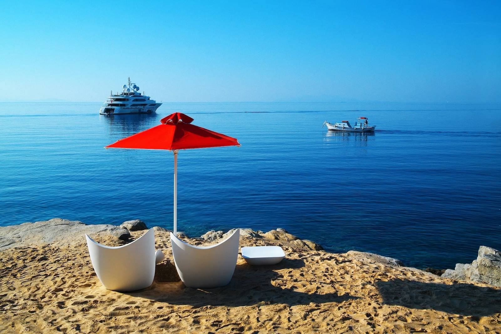 Petasos Beach Resort & Spa 私人海灘 La Petite Psarou 的陽傘與躺椅