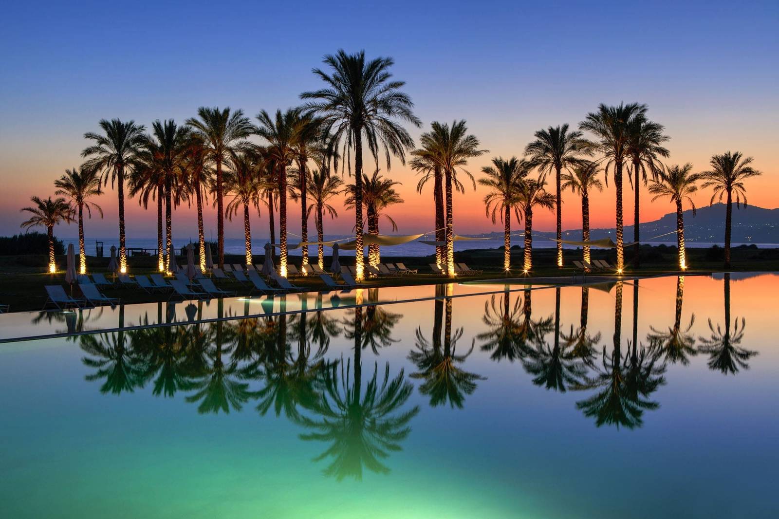 Verdura Resort 棕櫚樹環繞的無邊際泳池黃昏