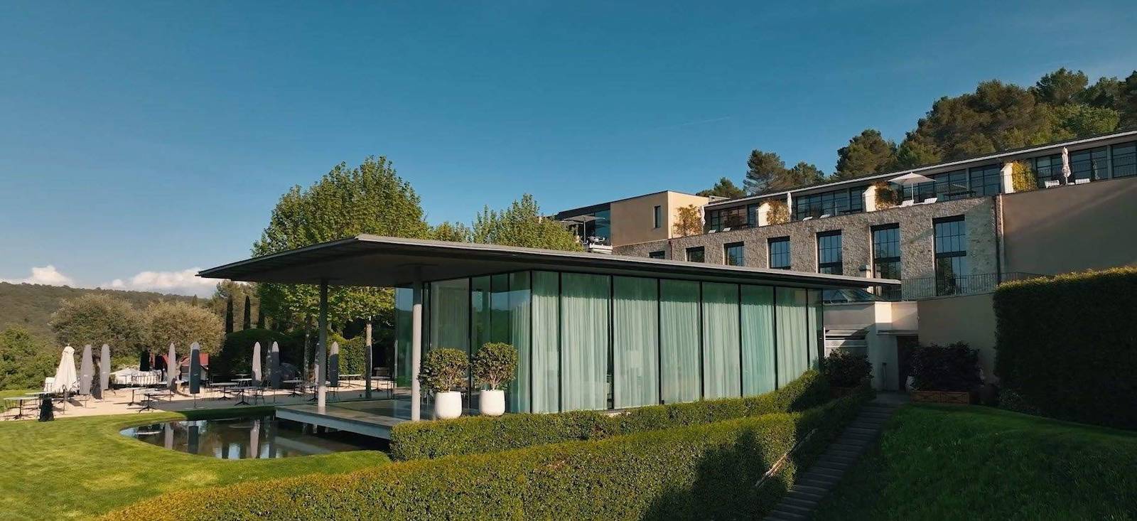 Villa La Coste 花園中的玻璃建築與石砌客房樓