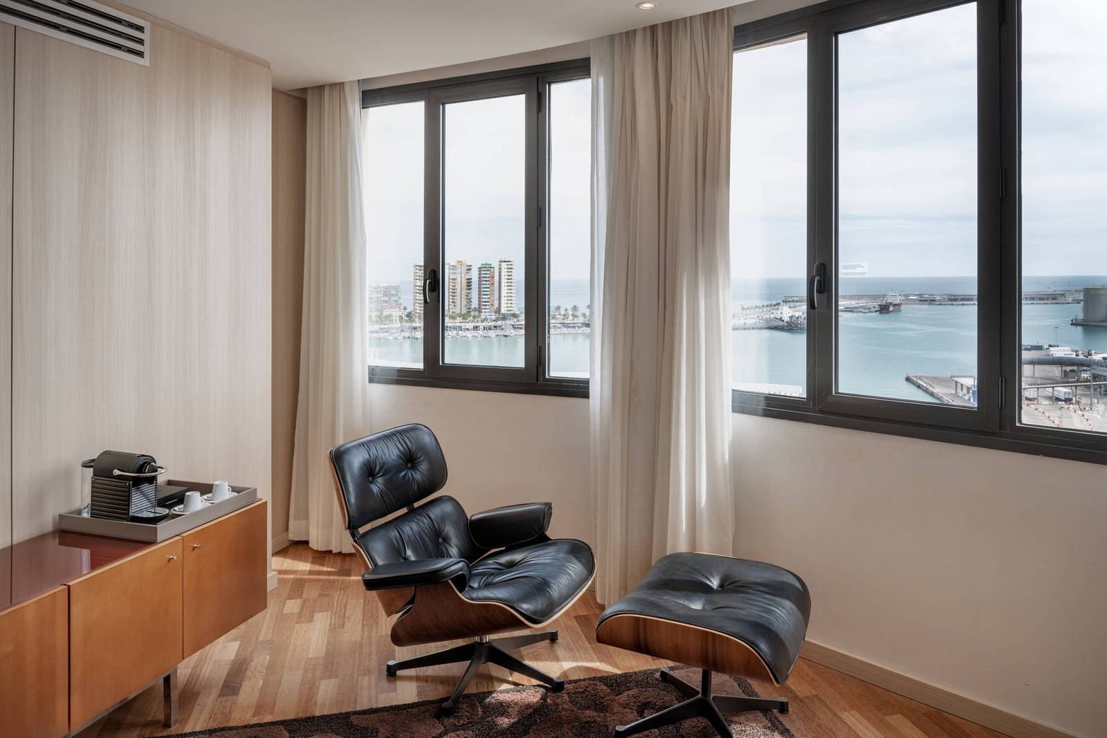 馬拉加 AC Hotel Málaga Palacio Suite 窗邊的皮革躺椅與港口景色