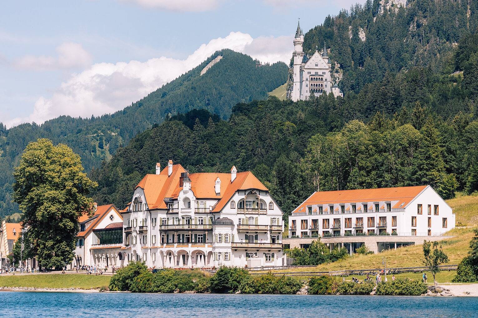 AMERON Neuschwanstein Alpsee Resort & Spa 湖畔建築群與後方山坡上的新天鵝堡