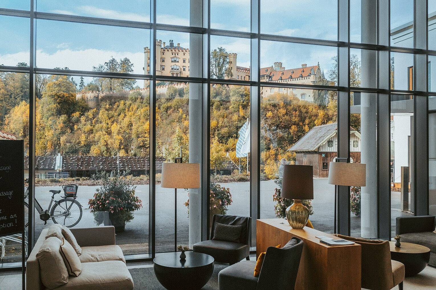 AMERON Neuschwanstein Alpsee Resort & Spa 落地玻璃大廳與窗外的高天鵝堡