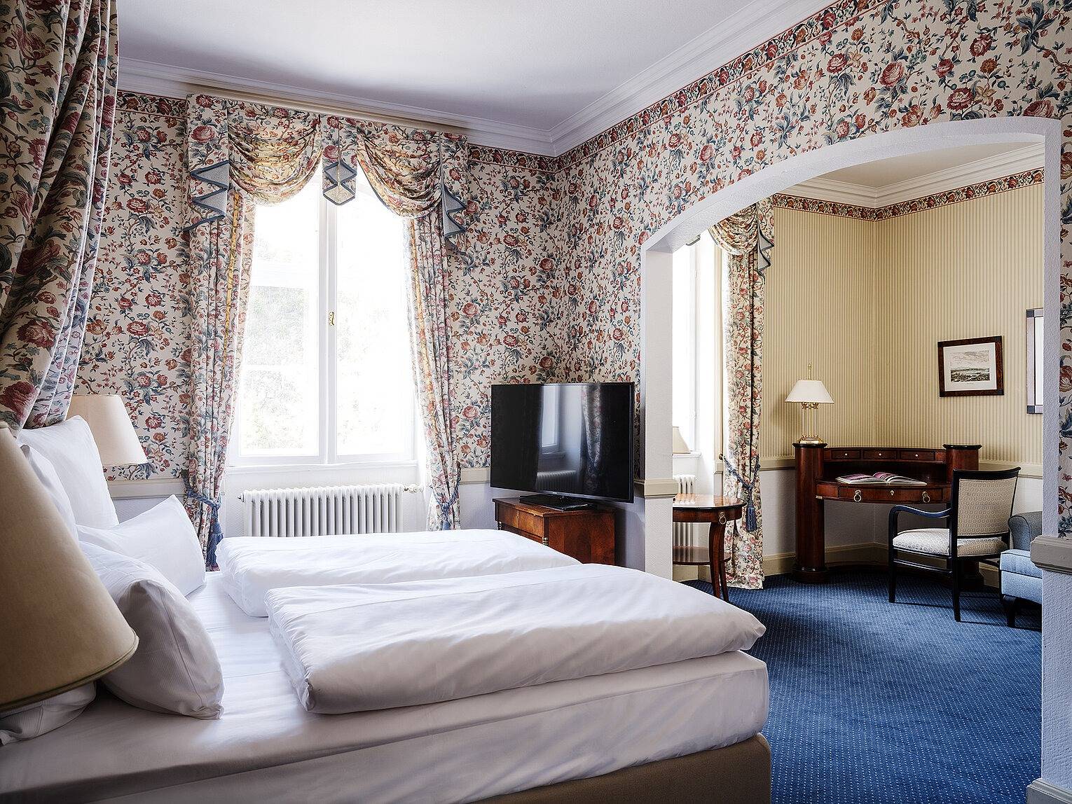 AMERON Neuschwanstein Alpsee Resort & Spa Jägerhaus 客房的花卉壁紙與雙人床