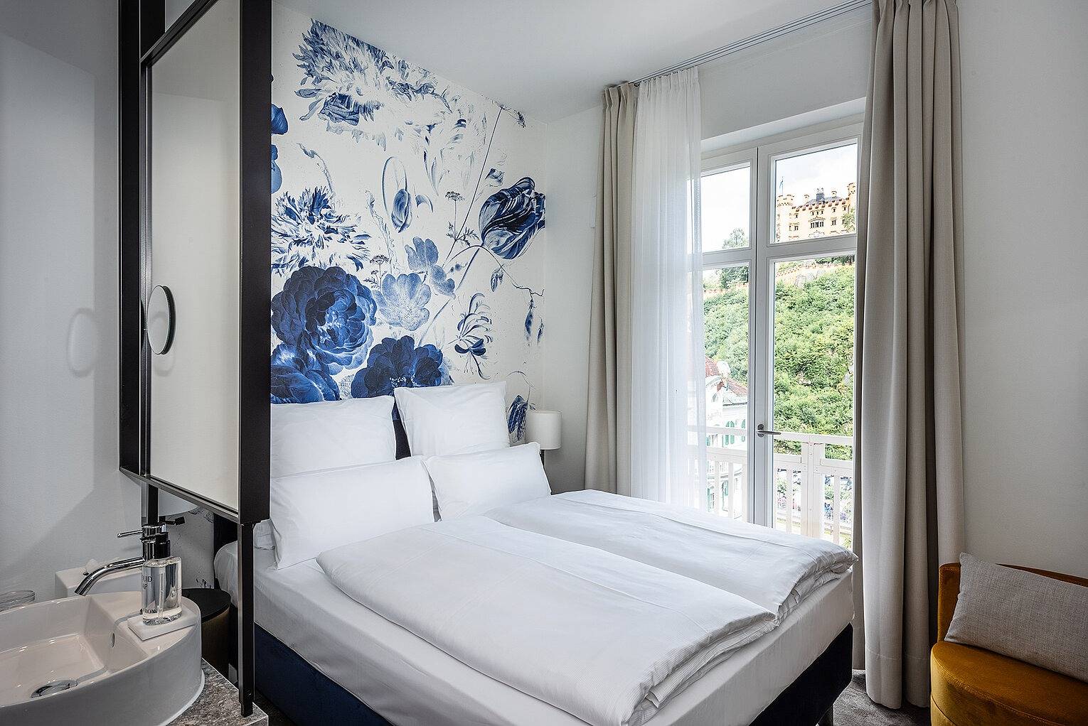 AMERON Neuschwanstein Alpsee Resort & Spa Lisl 客房的藍色花卉壁畫床頭