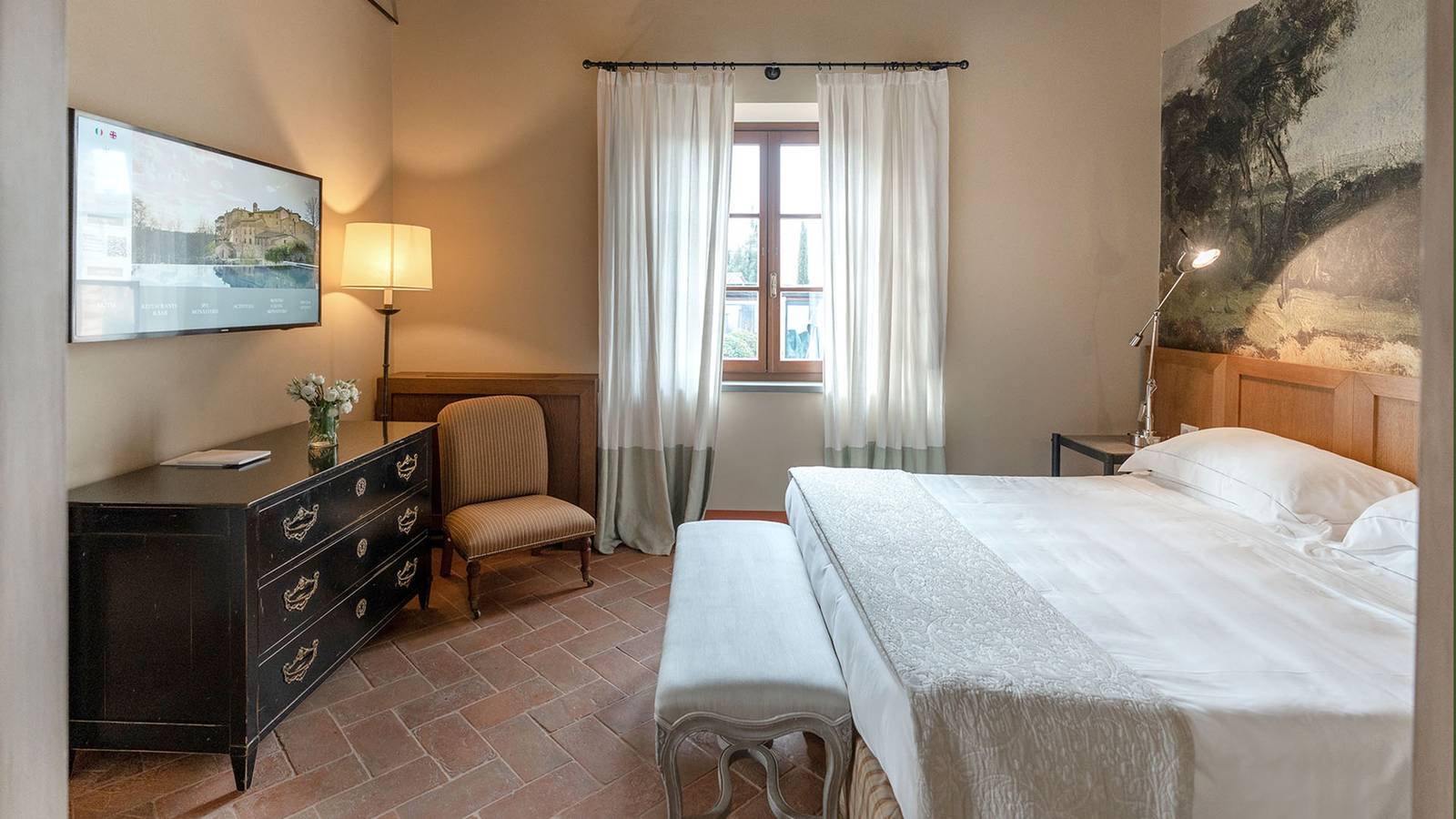 Castel Monastero Deluxe 客房的雙人床與赤陶地板