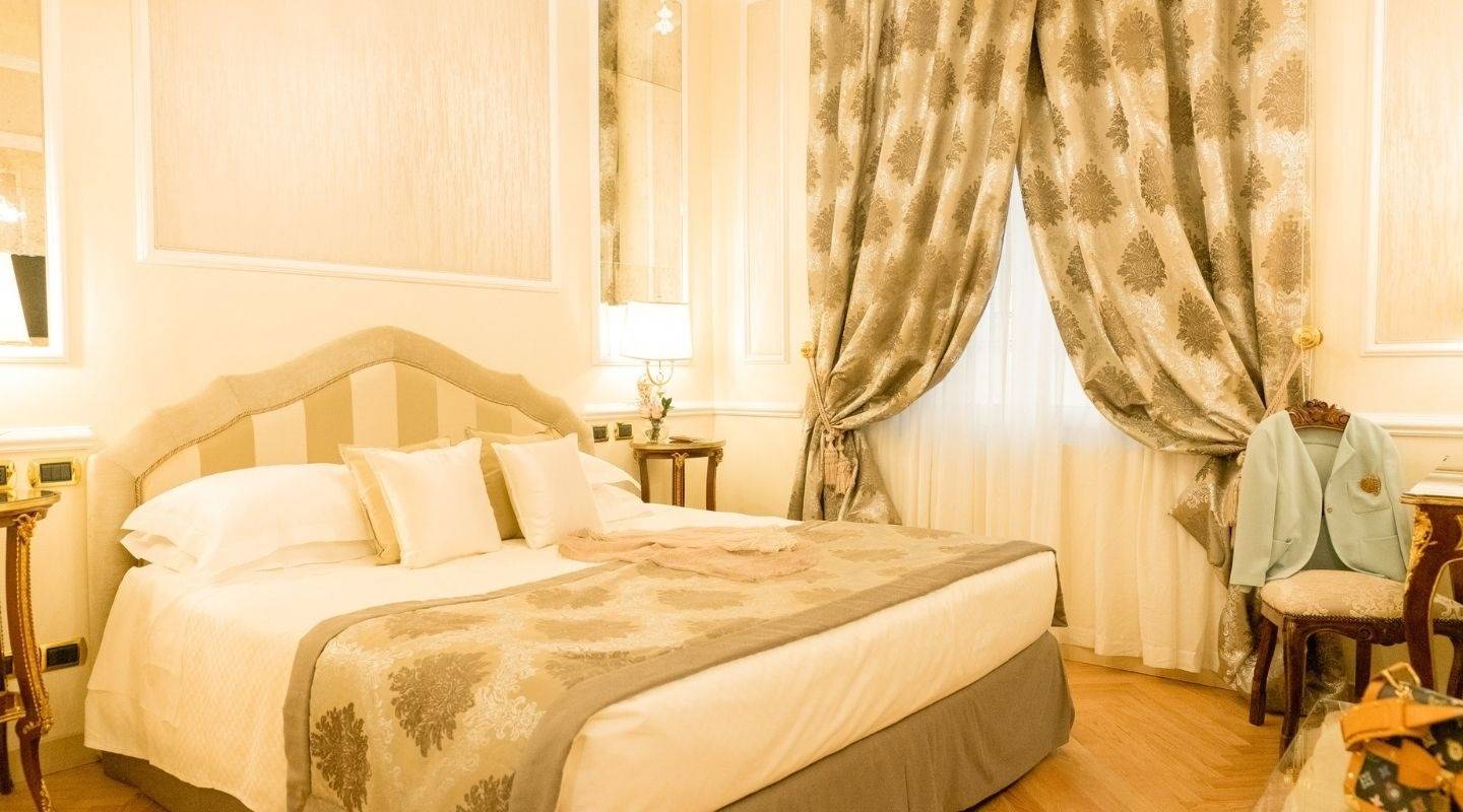 波隆那 Grand Hotel Majestic già Baglioni Classic & Superior 客房的大床與織花窗簾