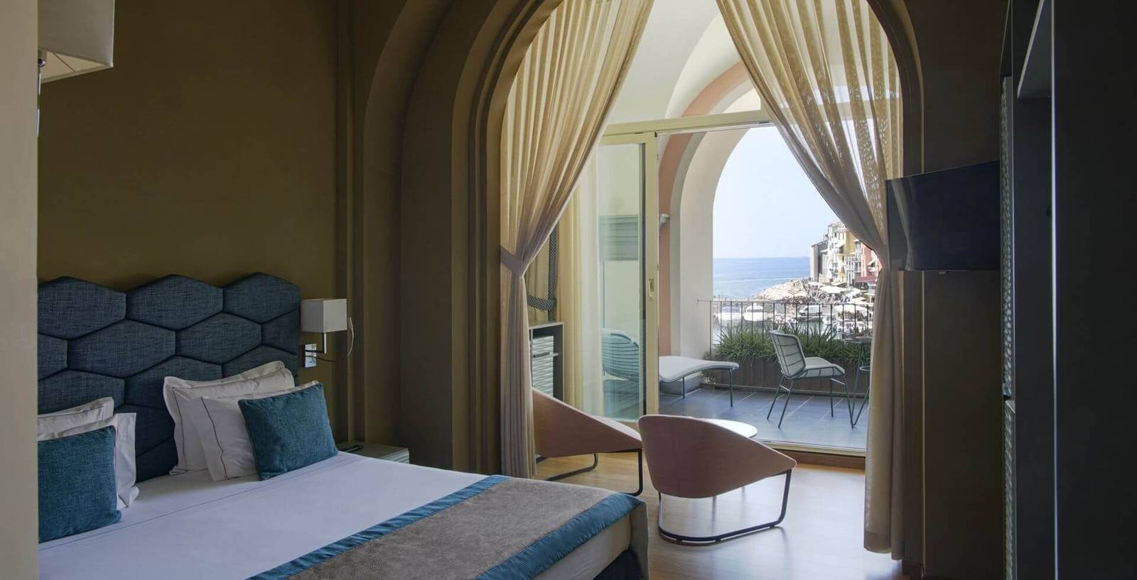 Grand Hotel Portovenere Junior Suite 六角床頭板與拱窗外的海港