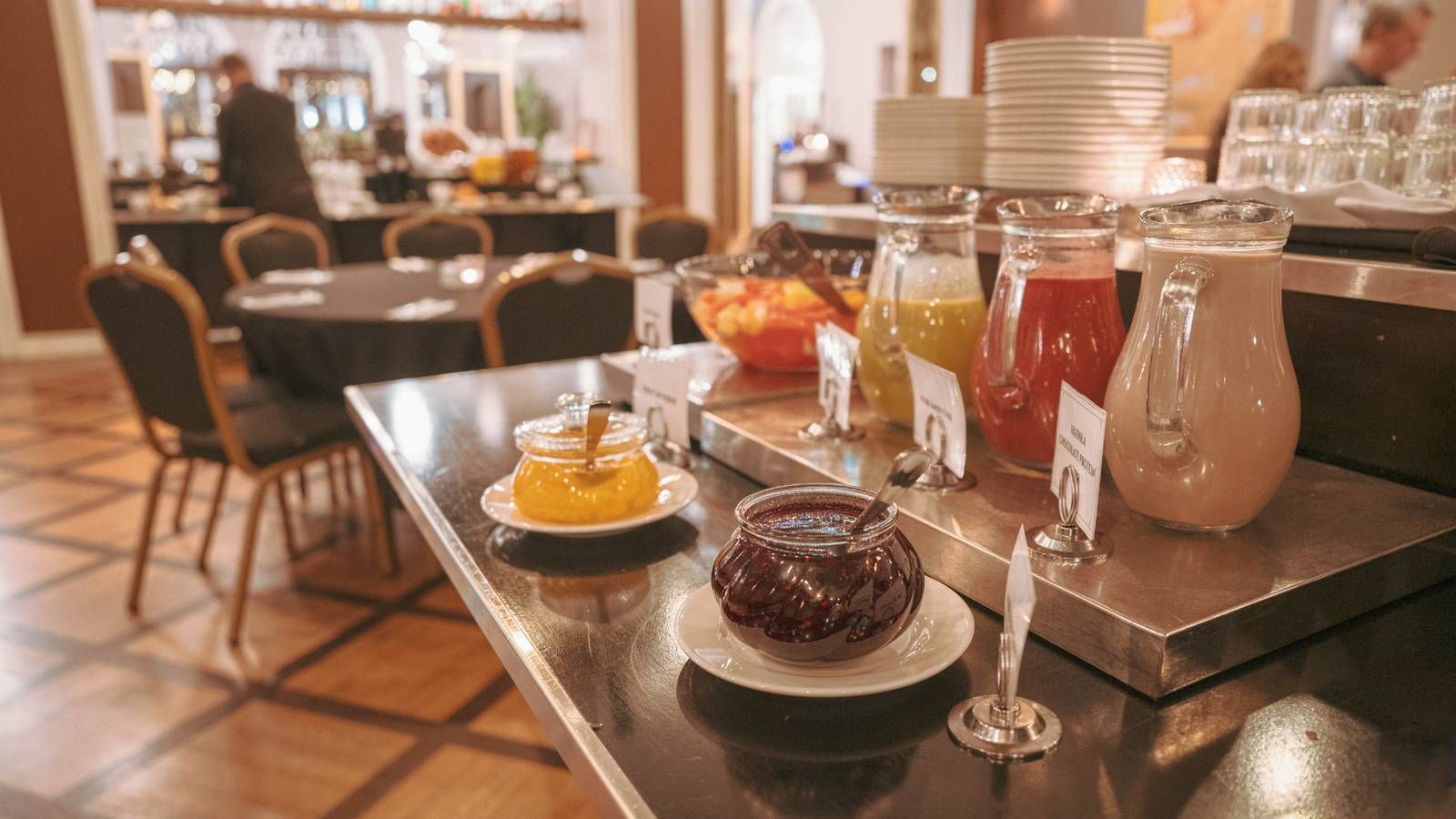 雷克雅維克 Hotel Borg 早餐室的果醬、果汁與木地板用餐區