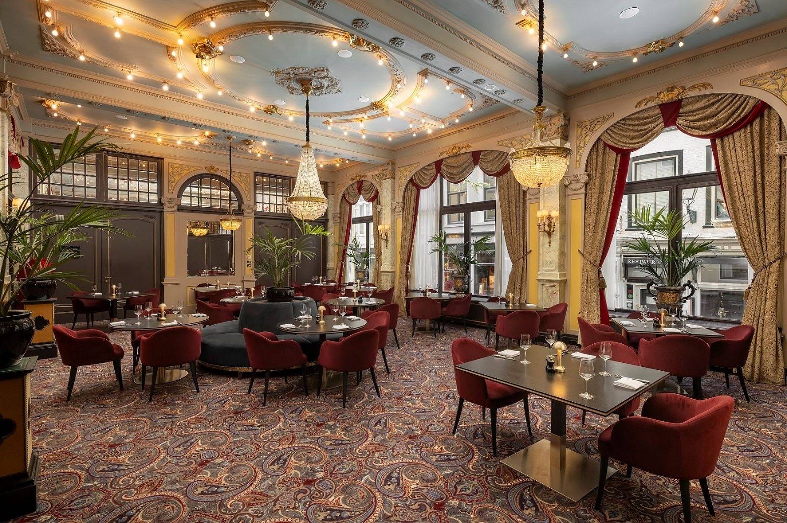 海牙 Hotel Des Indes 餐廳的水晶吊燈、帷幔與紅色座椅