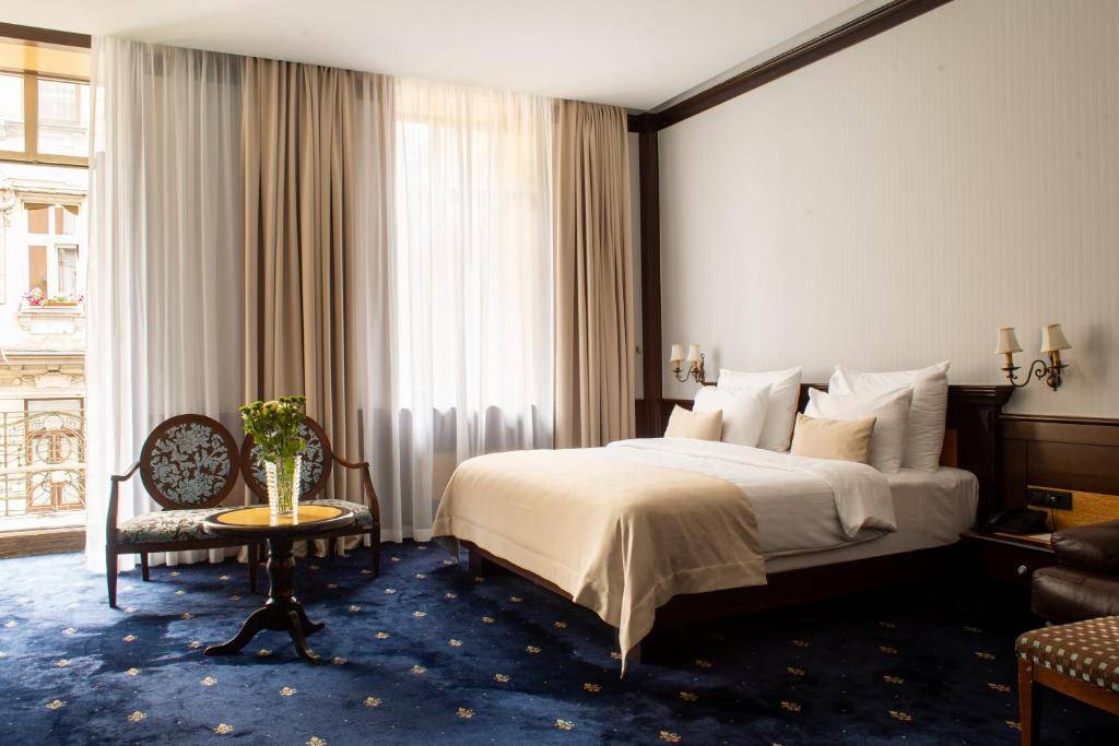 塞拉耶佛 Hotel Europe Superior Austro-Hungarian 客房的大床與古典扶手椅