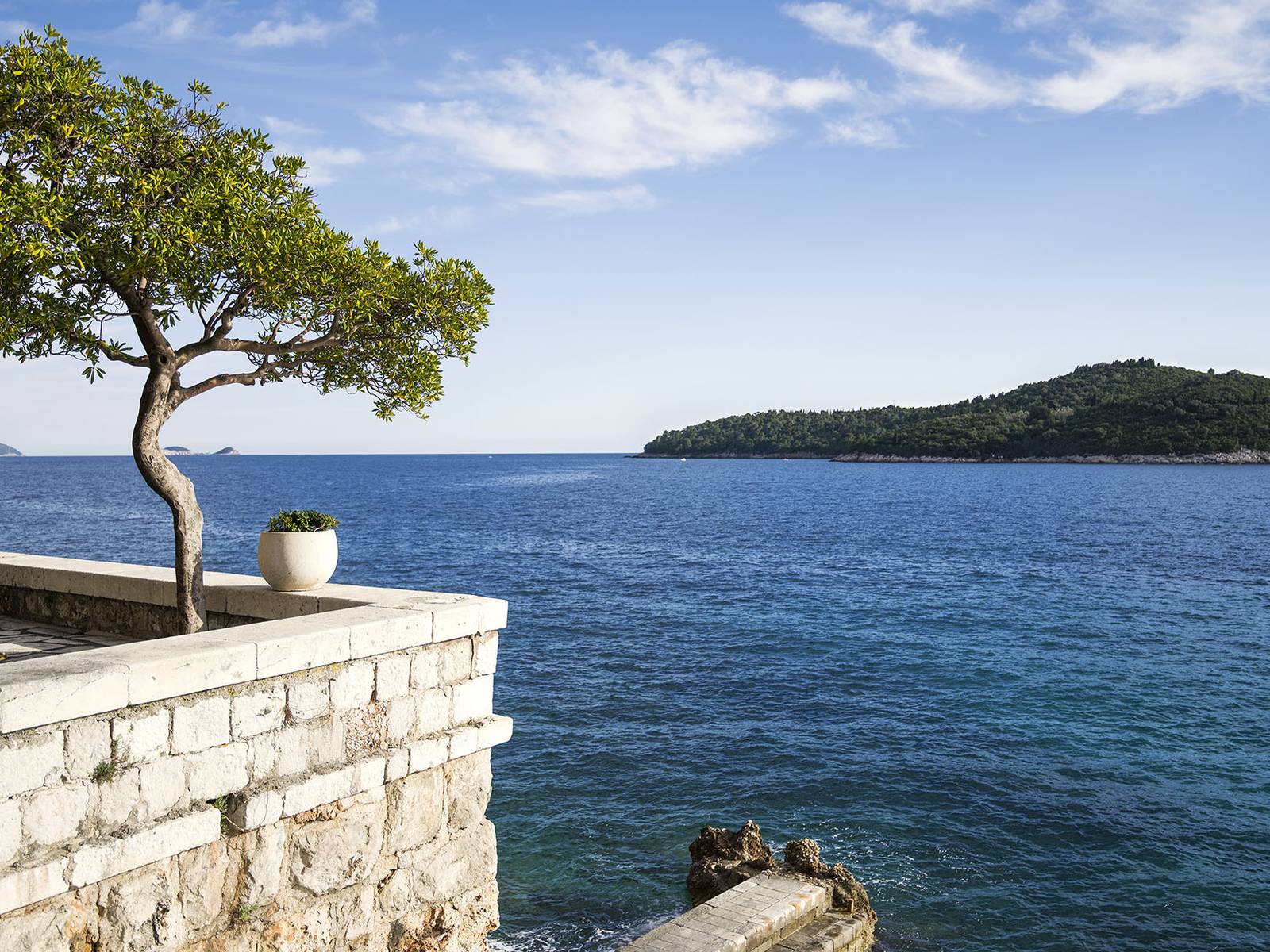 Hotel Excelsior Dubrovnik 石砌露台、松樹與對面的洛克魯姆島