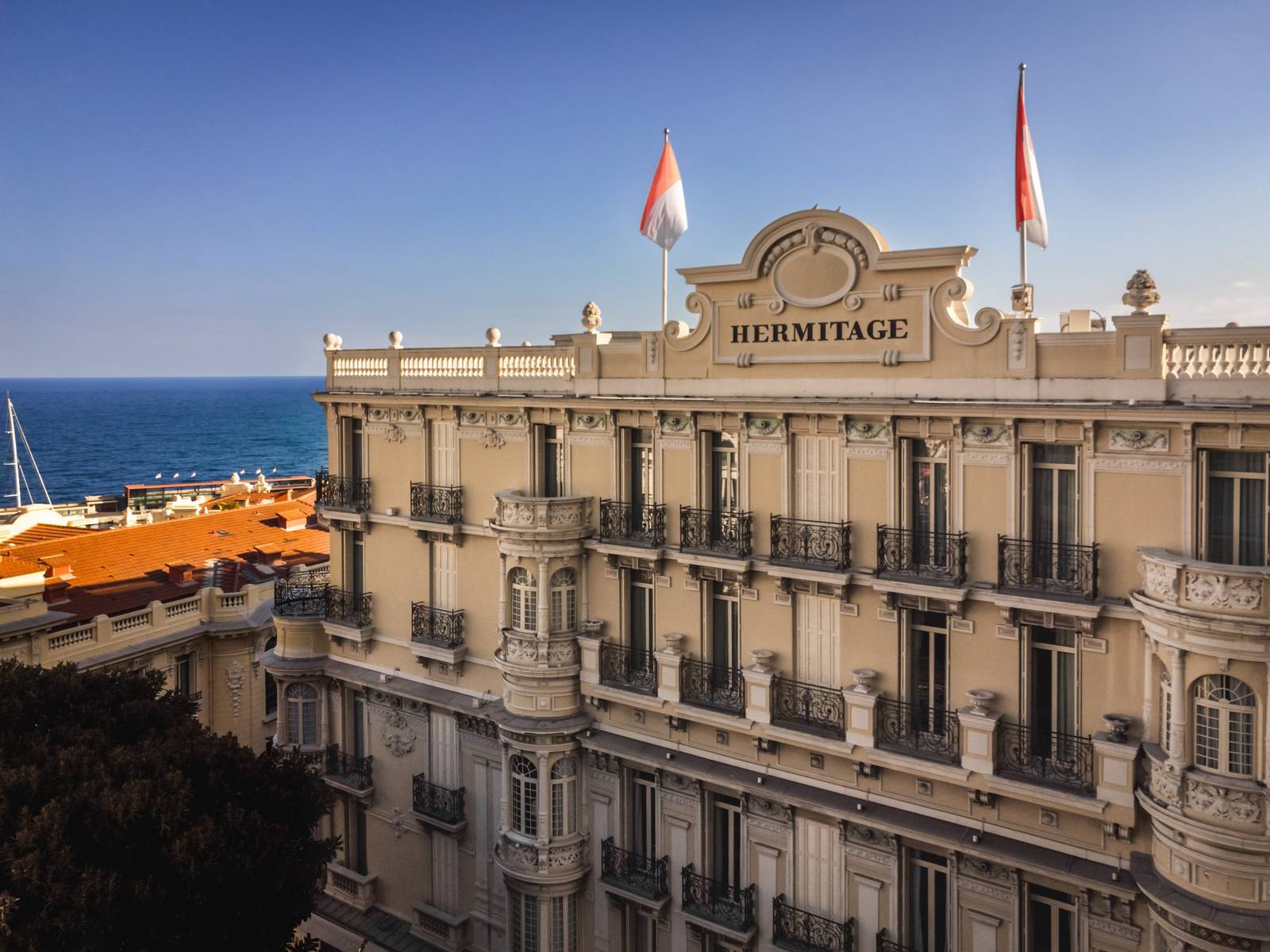 Hôtel Hermitage Monte-Carlo 掛有飯店名的立面與後方海景