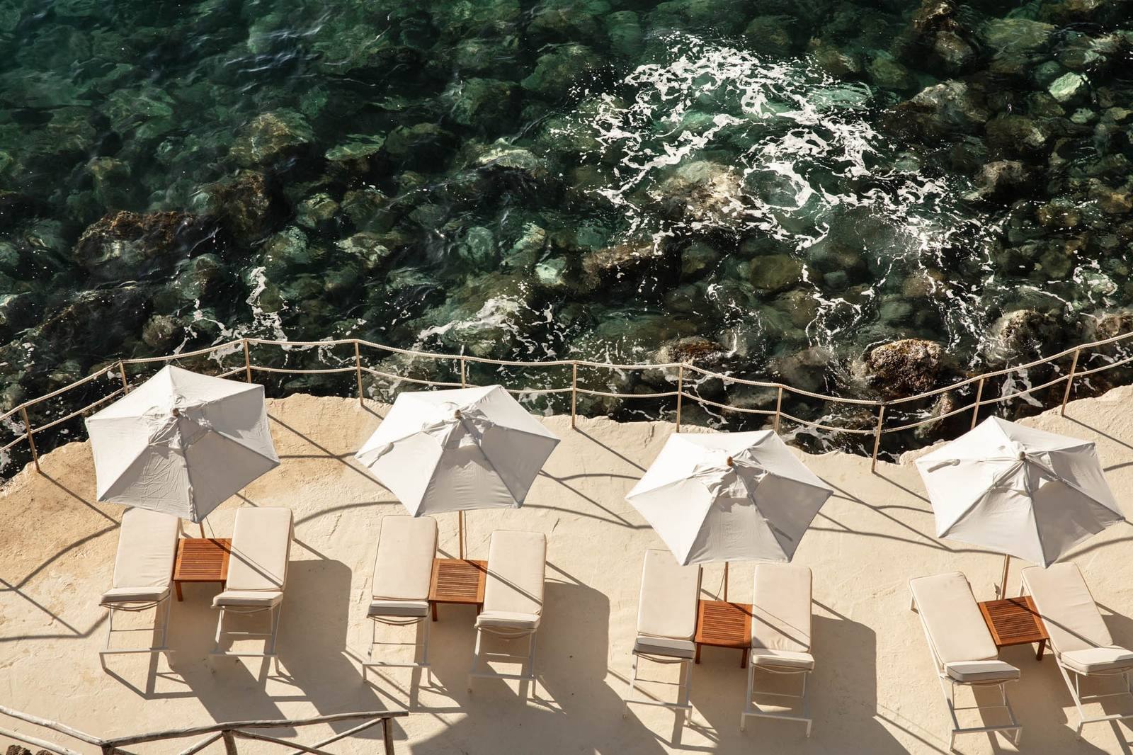 Il Pellicano 酒店海灘俱樂部的礁岩日光平台與陽傘