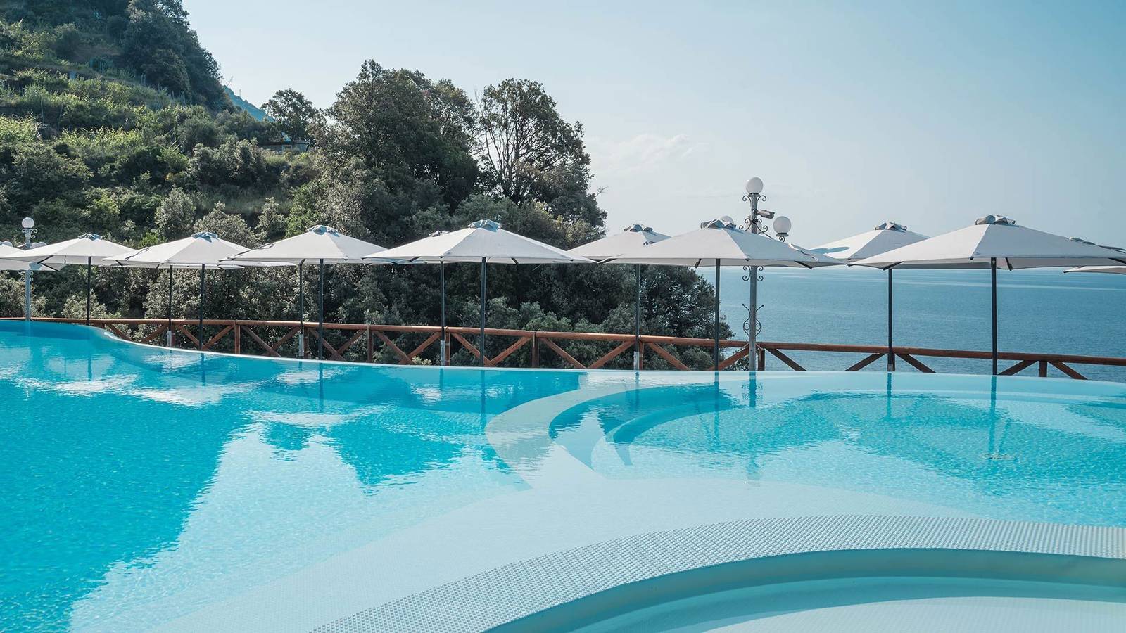 Hotel Porto Roca 泳池與成排遮陽傘