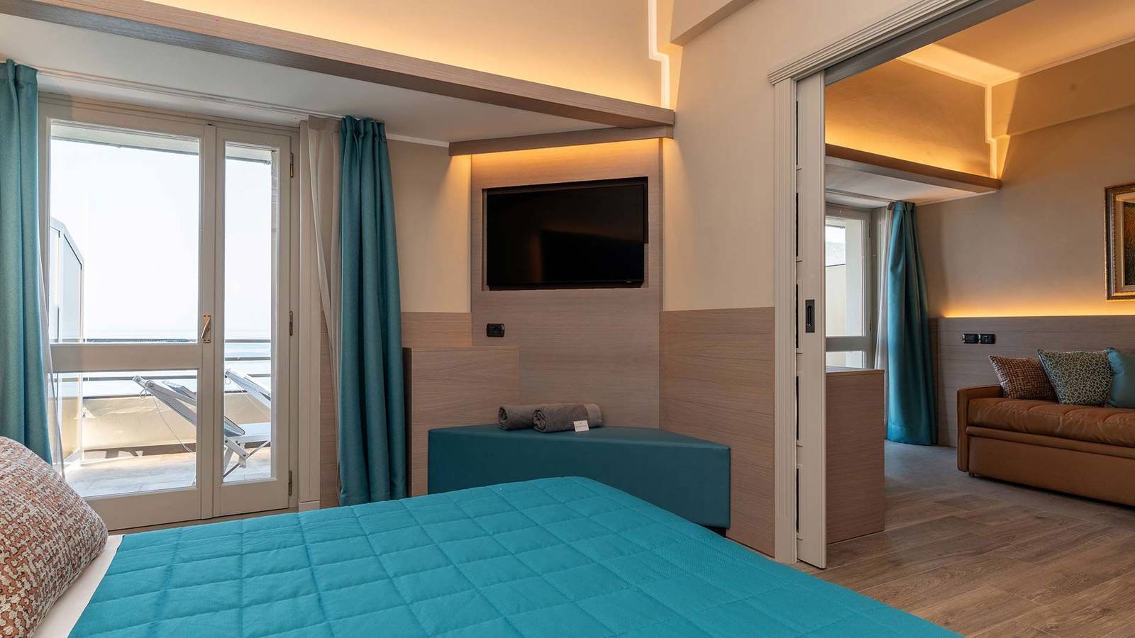 Hotel Porto Roca 套房臥室與相連的起居區