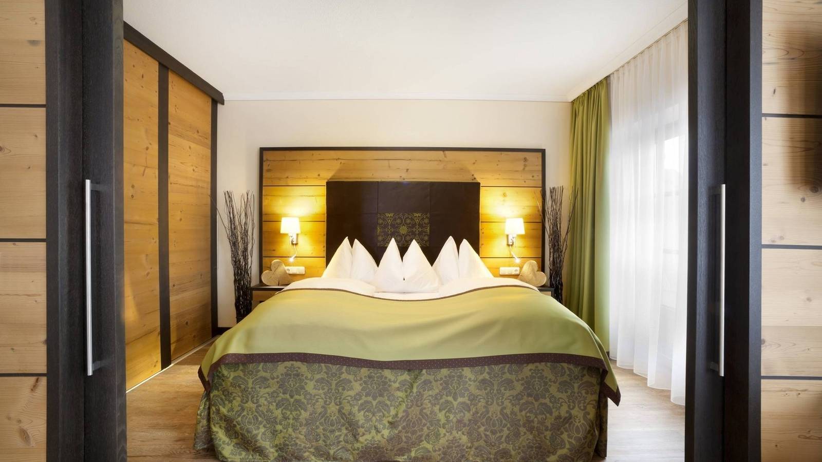 福森 Hotel Sommer 家庭房的雙人床與木質衣櫃