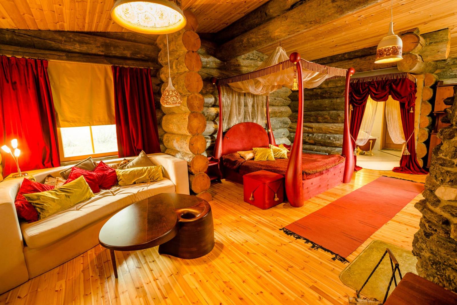 Kakslauttanen Arctic Resort Queen Suite 木屋內的四柱床與起居區