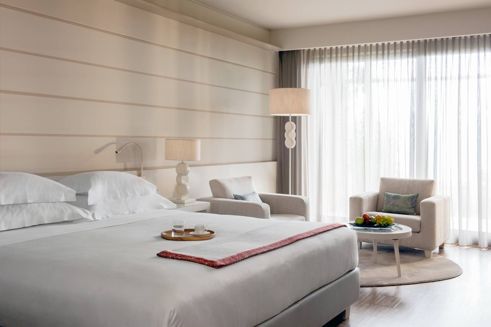 Lefay Resort & SPA Junior Suite 的雙人床與起居角