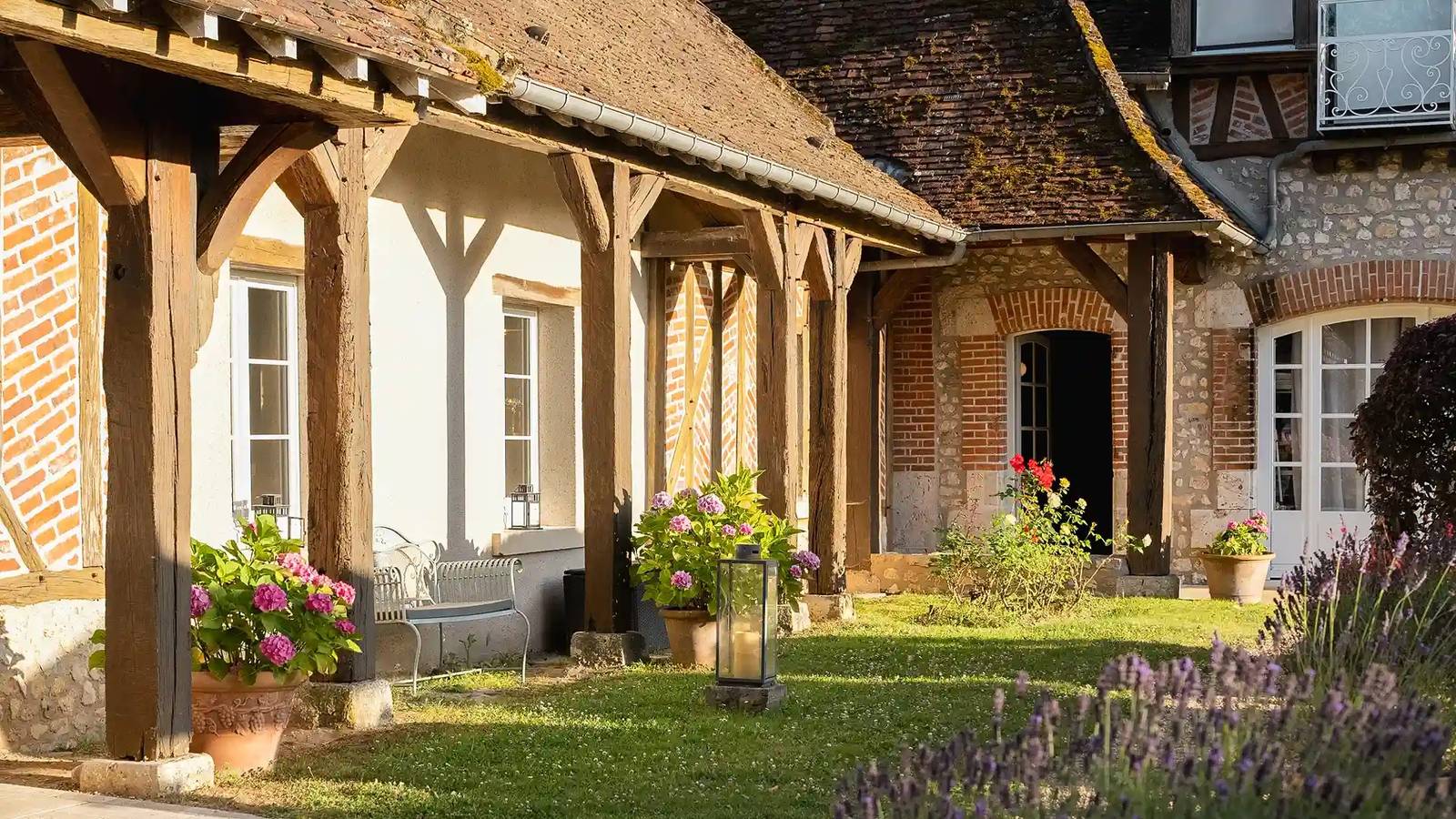 Les Hauts de Loire La Demeure 的半木構紅磚建築與花圃