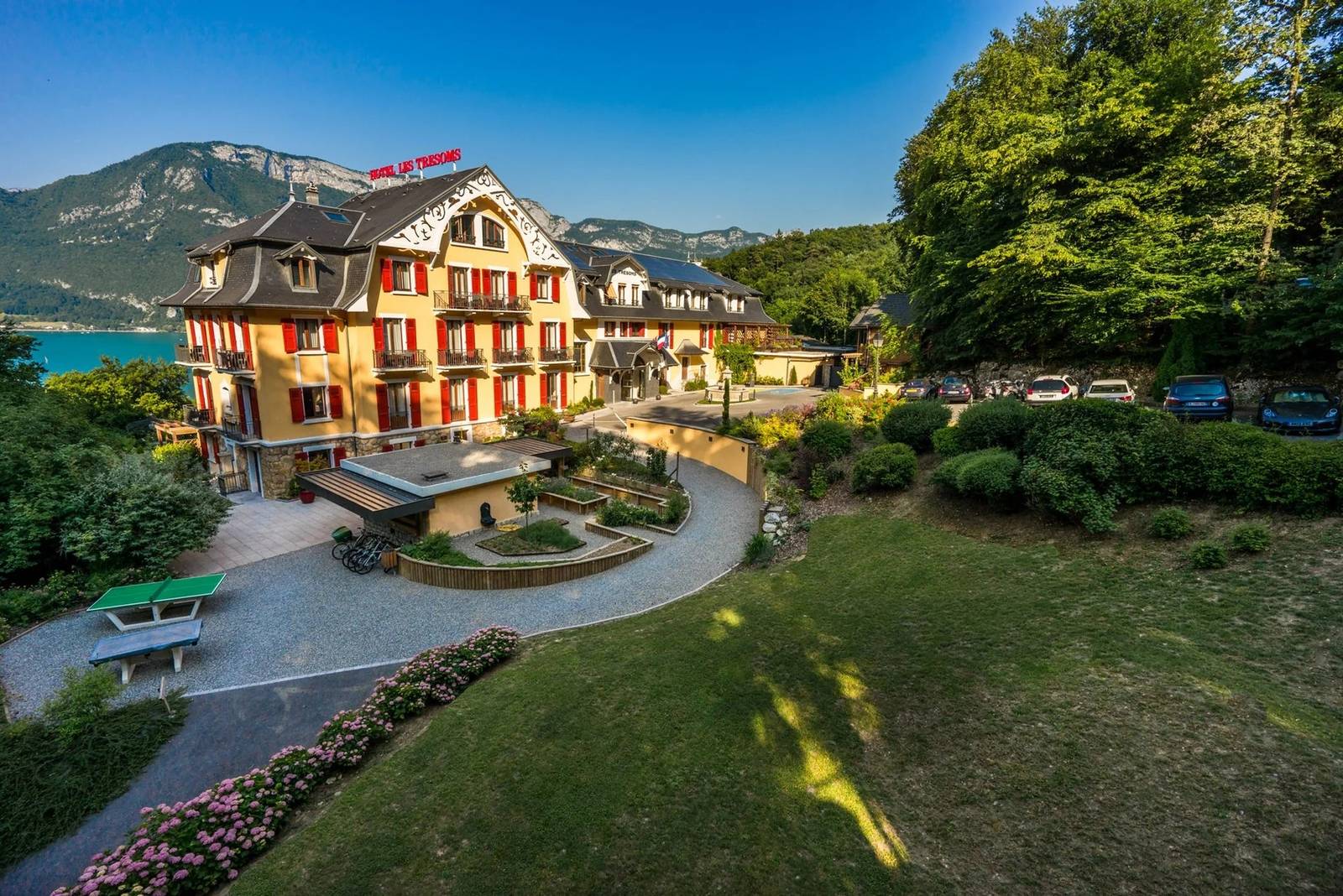 安錫 Les Trésoms 黃色外牆建築與前方花園