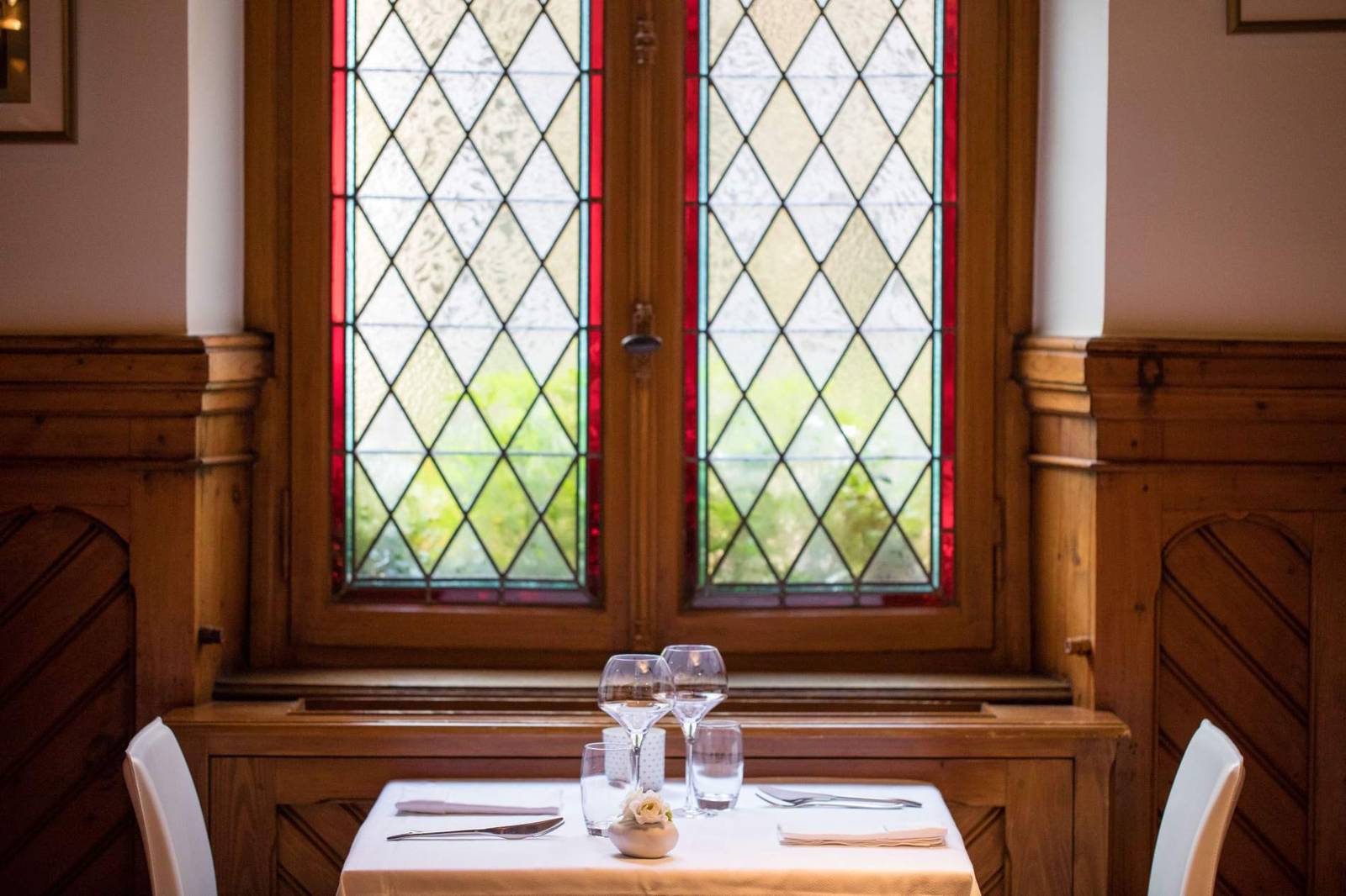 科爾馬 La Maison des Têtes 鉛框彩繪玻璃窗與木牆板旁的餐桌