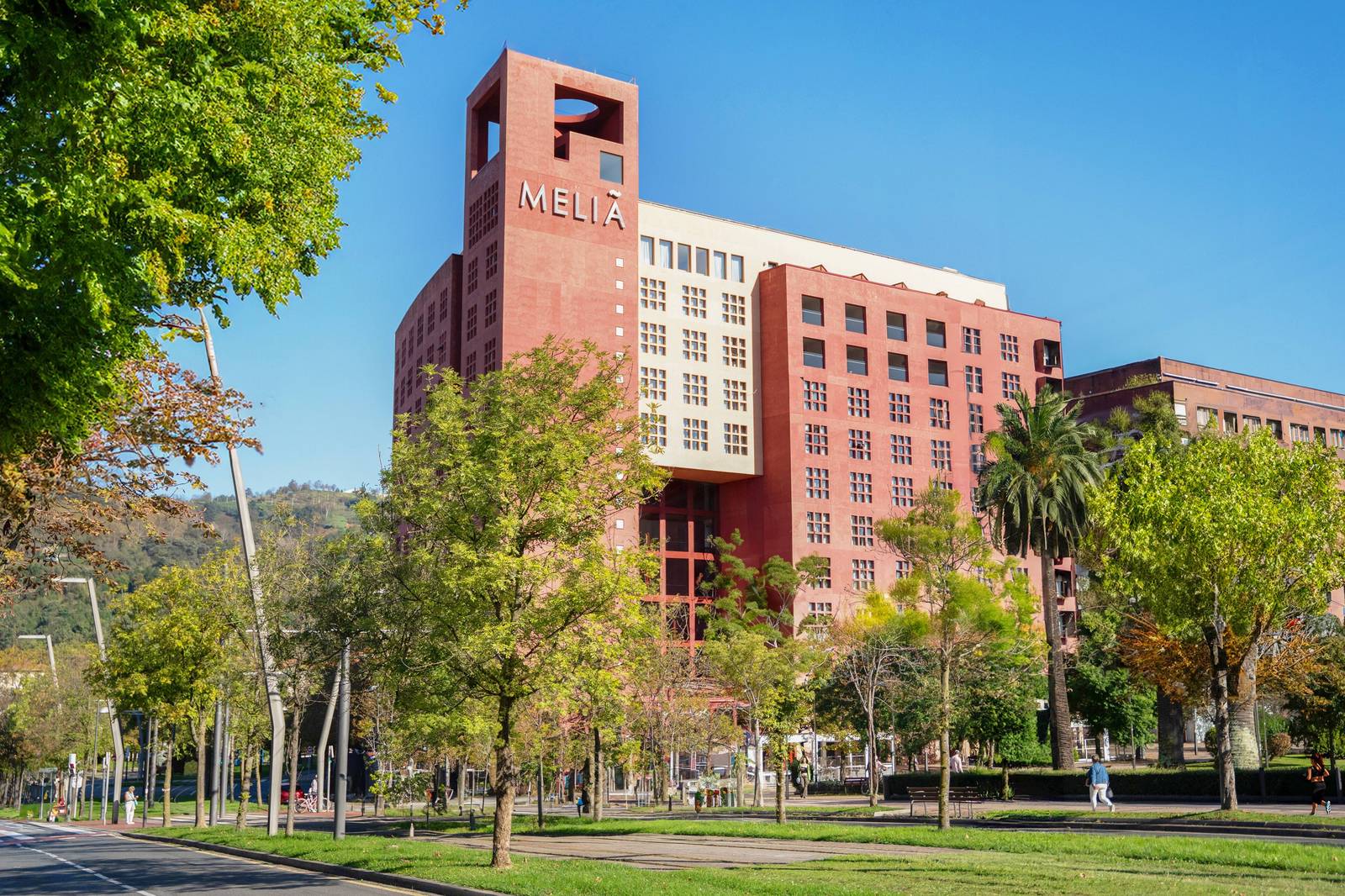 畢爾包 Meliá Bilbao 紅色外牆的建築與綠樹大道