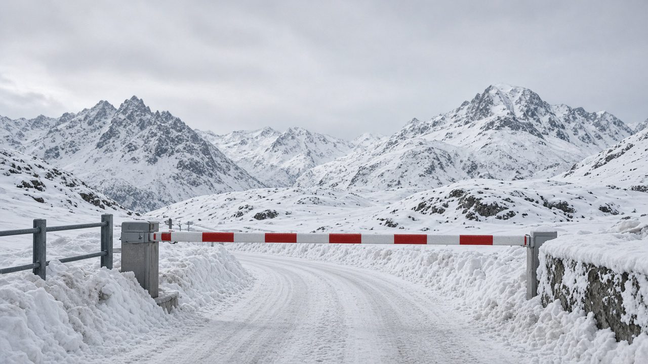 積雪的瑞士阿爾卑斯山口道路,紅白柵欄橫在路中央封路