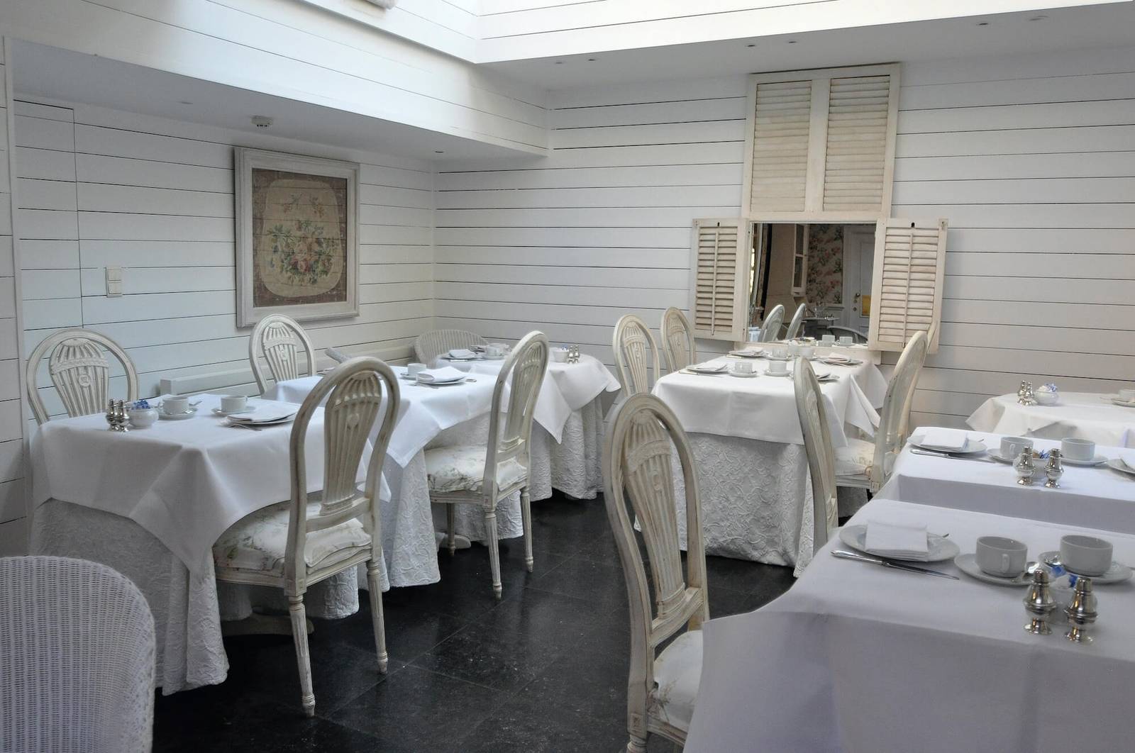 布魯日 The Pand Hotel 白色木牆早餐室與鋪白桌巾的餐桌