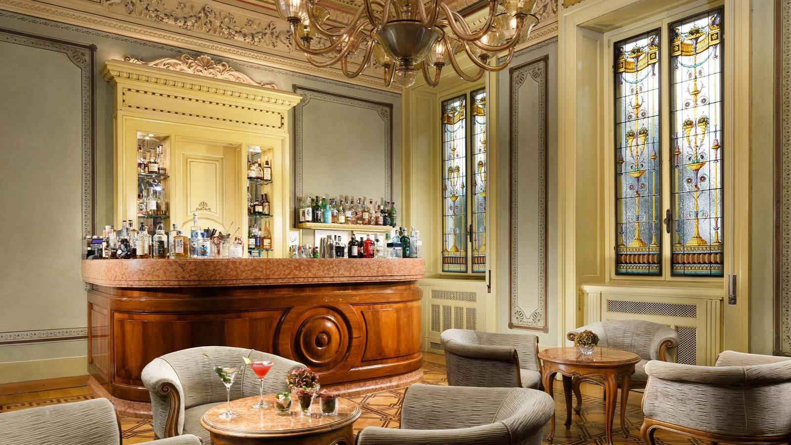 Villa Cortine Palace Koseritz Bar 的木質吧台與彩繪玻璃窗