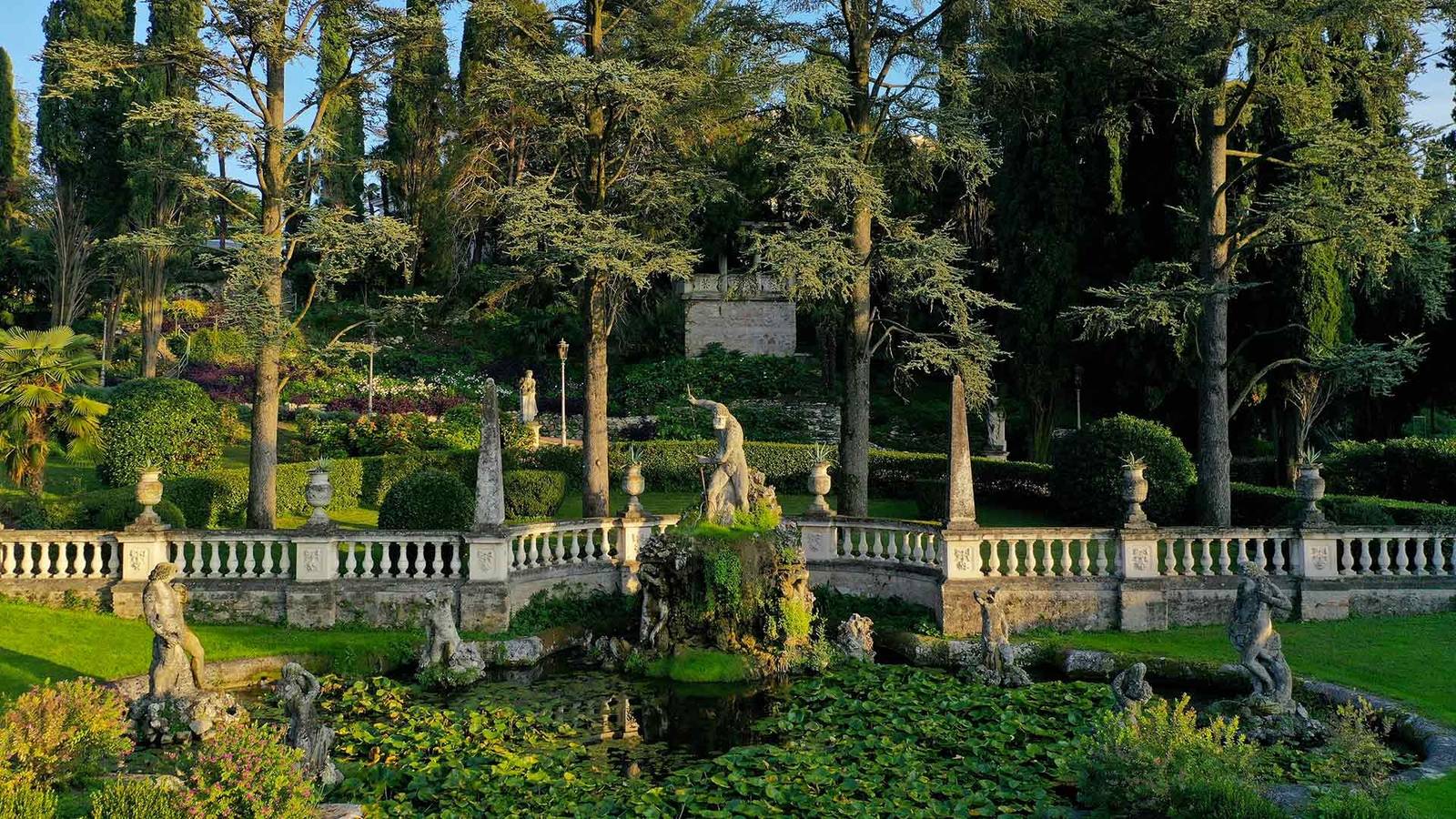 Villa Cortine Palace 公園裡的雕像、欄杆與花木