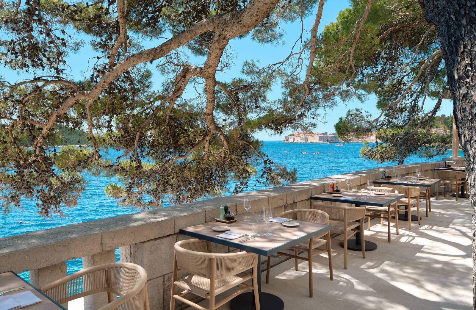 Villa Dubrovnik Giardino 餐廳松樹下的露台餐桌與海景