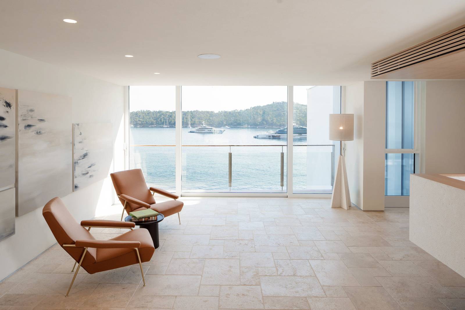 Villa Dubrovnik 大廳的石材地板、皮革單椅與落地窗海景